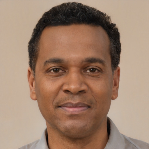Joyful latino adult male with short  black hair and brown eyes