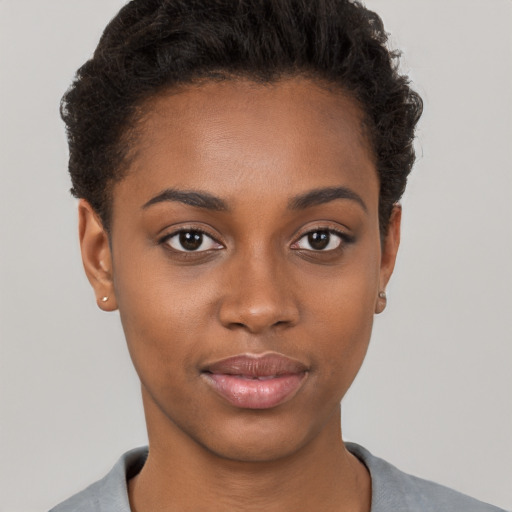 Joyful black young-adult female with short  brown hair and brown eyes