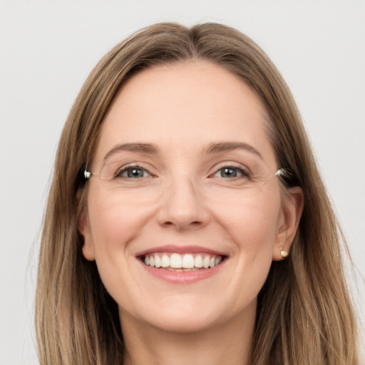 Joyful white young-adult female with long  brown hair and grey eyes