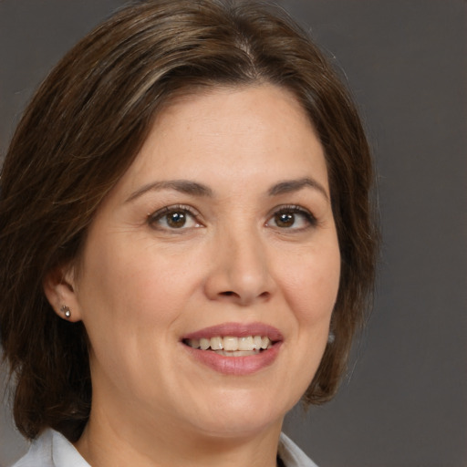 Joyful white adult female with medium  brown hair and brown eyes