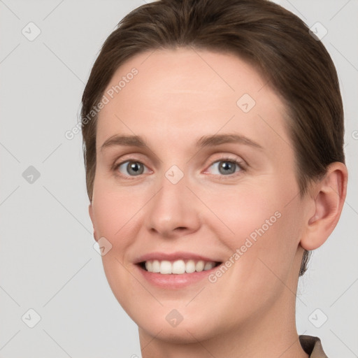 Joyful white young-adult female with short  brown hair and grey eyes