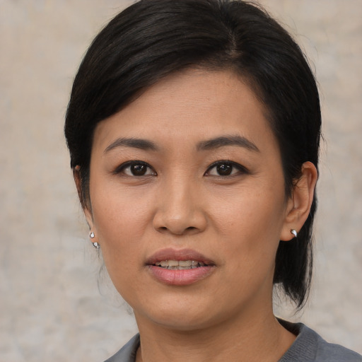 Joyful asian young-adult female with medium  black hair and brown eyes