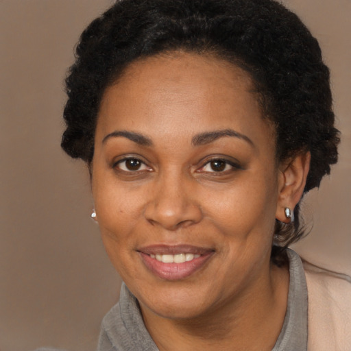 Joyful black adult female with short  brown hair and brown eyes