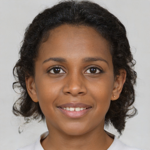 Joyful black young-adult female with medium  brown hair and brown eyes