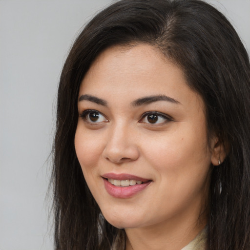 Joyful latino young-adult female with long  brown hair and brown eyes