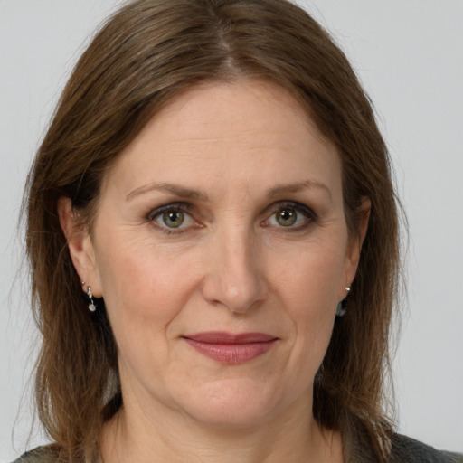 Joyful white adult female with medium  brown hair and grey eyes