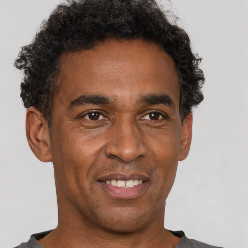 Joyful black adult male with short  brown hair and brown eyes
