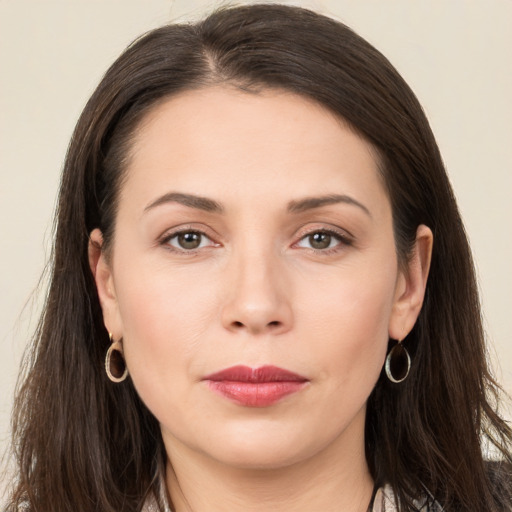 Joyful white young-adult female with long  brown hair and brown eyes