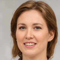 Joyful white young-adult female with medium  brown hair and green eyes