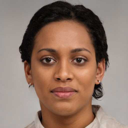 Joyful black young-adult female with short  brown hair and brown eyes