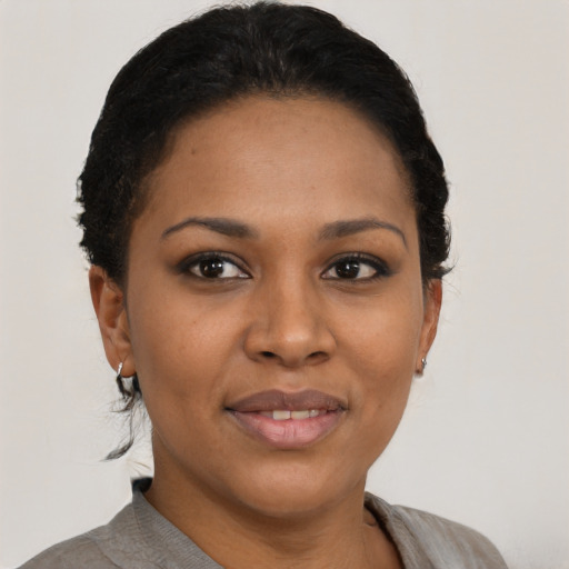 Joyful black young-adult female with short  black hair and brown eyes