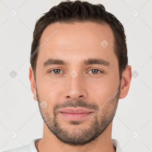 Joyful white young-adult male with short  black hair and brown eyes