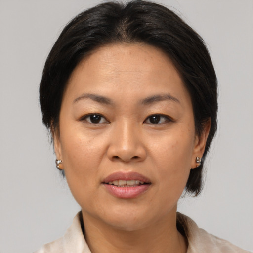 Joyful asian adult female with medium  brown hair and brown eyes