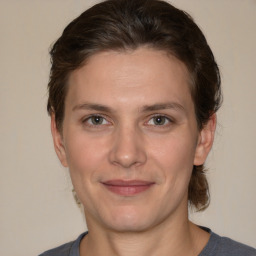 Joyful white young-adult female with medium  brown hair and grey eyes