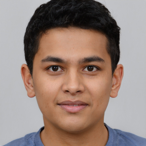 Joyful latino young-adult male with short  black hair and brown eyes