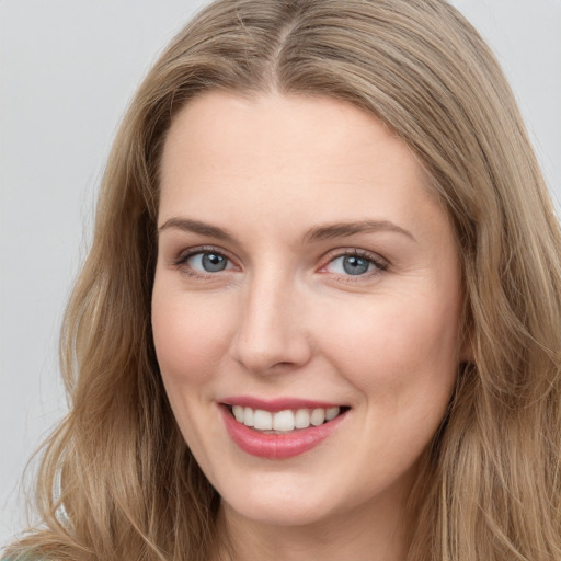 Joyful white young-adult female with long  brown hair and blue eyes