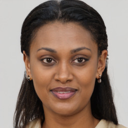 Joyful black young-adult female with long  brown hair and brown eyes