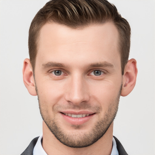 Joyful white young-adult male with short  brown hair and grey eyes