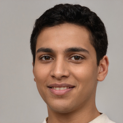 Joyful latino young-adult male with short  brown hair and brown eyes