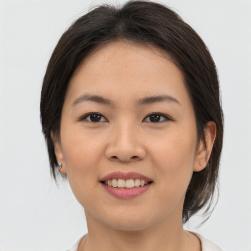 Joyful asian young-adult female with medium  brown hair and brown eyes