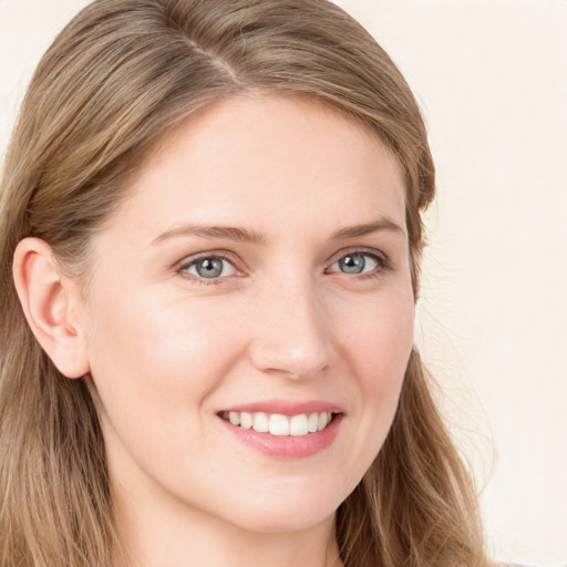 Joyful white young-adult female with long  brown hair and blue eyes