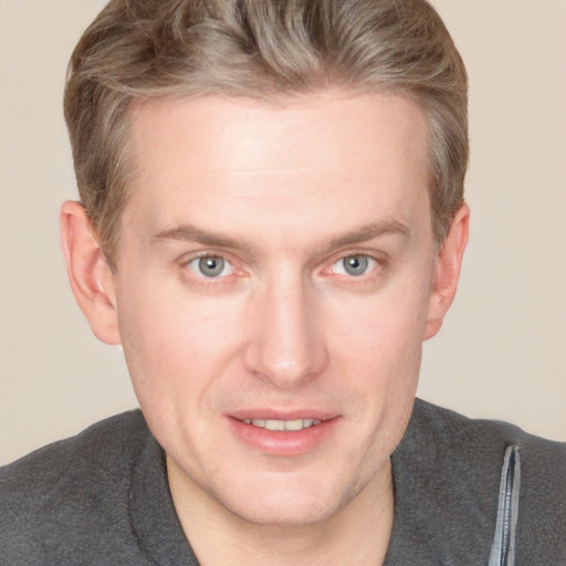 Joyful white adult male with short  brown hair and blue eyes