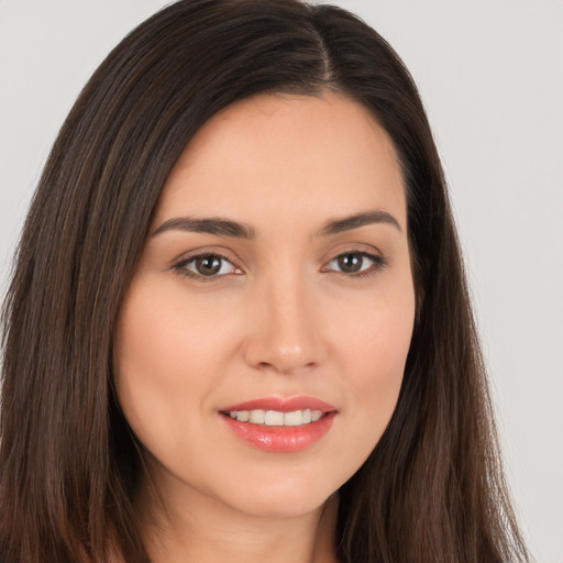 Joyful white young-adult female with long  brown hair and brown eyes