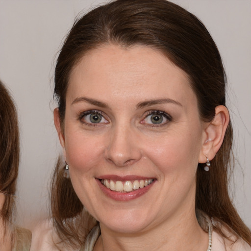 Joyful white adult female with medium  brown hair and blue eyes