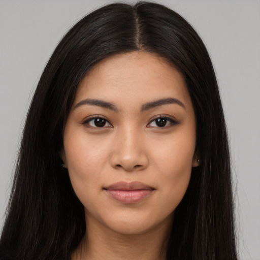 Joyful latino young-adult female with long  black hair and brown eyes