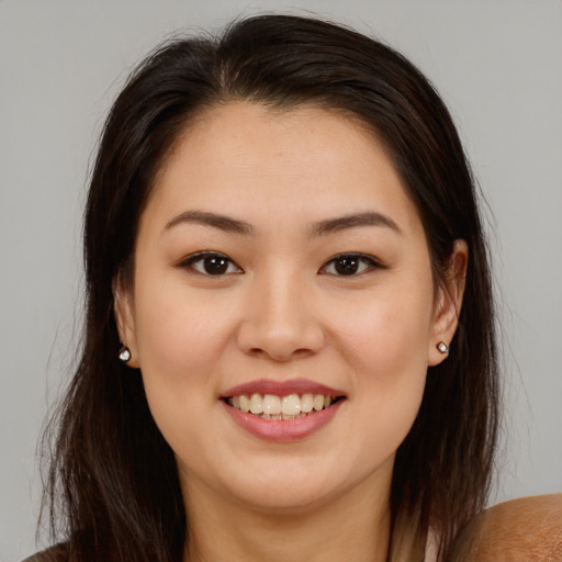 Joyful latino young-adult female with long  brown hair and brown eyes