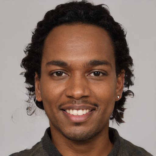 Joyful black young-adult male with short  brown hair and brown eyes
