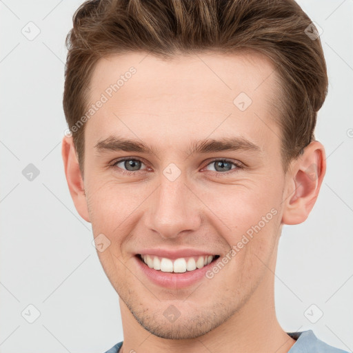 Joyful white young-adult male with short  brown hair and grey eyes