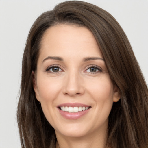 Joyful white young-adult female with long  brown hair and brown eyes