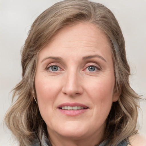 Joyful white adult female with medium  brown hair and blue eyes