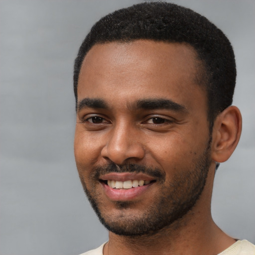 Joyful black young-adult male with short  black hair and brown eyes