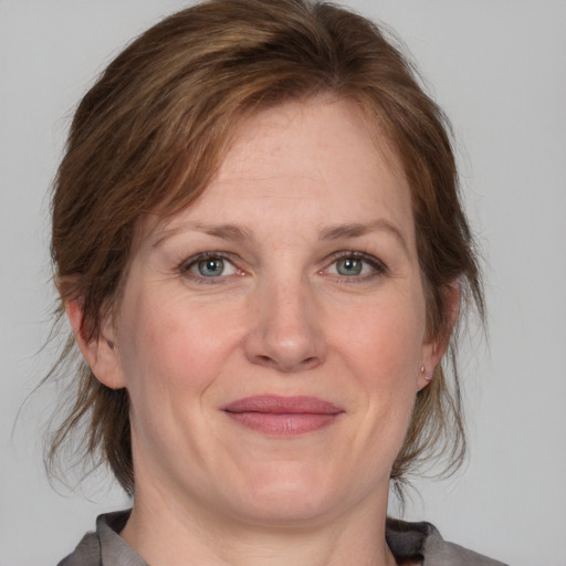 Joyful white adult female with medium  brown hair and grey eyes