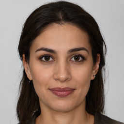 Joyful latino young-adult female with medium  brown hair and brown eyes