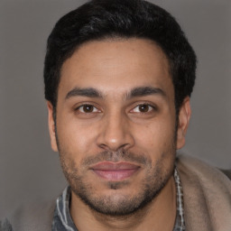 Joyful latino young-adult male with short  black hair and brown eyes