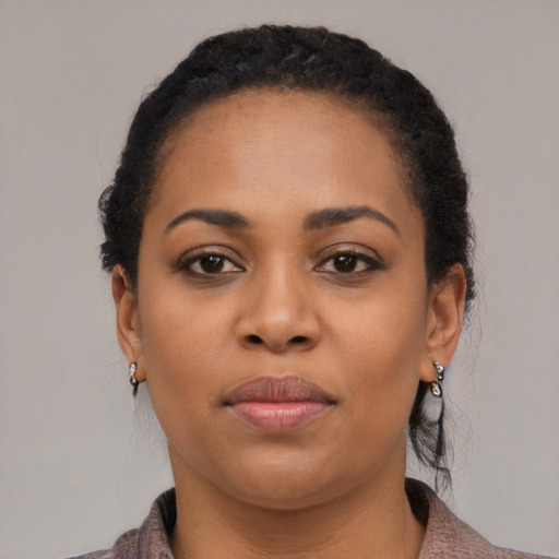 Joyful black young-adult female with medium  black hair and brown eyes