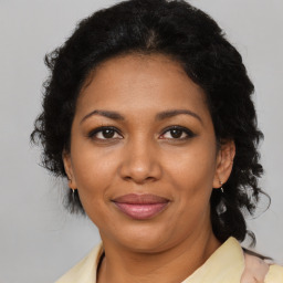 Joyful black adult female with medium  brown hair and brown eyes