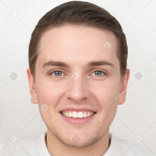 Joyful white young-adult male with short  brown hair and grey eyes