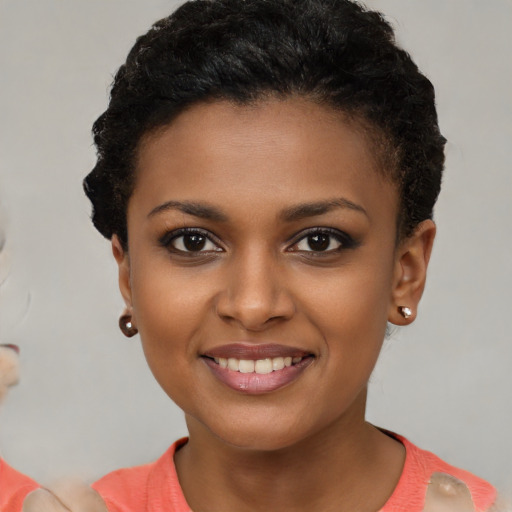 Joyful black young-adult female with short  brown hair and brown eyes