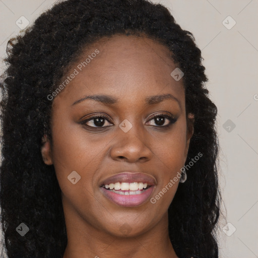 Joyful black young-adult female with long  brown hair and brown eyes