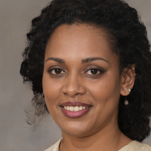 Joyful black young-adult female with medium  black hair and brown eyes