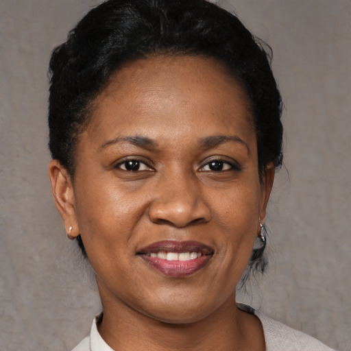 Joyful black adult female with short  black hair and brown eyes
