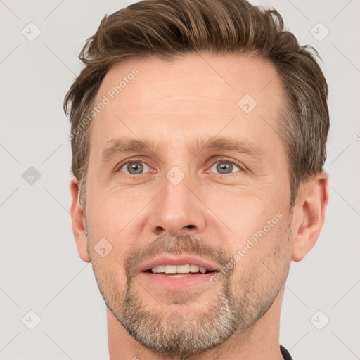 Joyful white adult male with short  brown hair and grey eyes