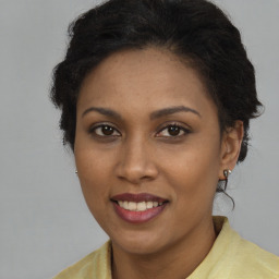 Joyful black young-adult female with long  brown hair and brown eyes