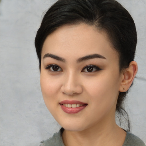 Joyful asian young-adult female with medium  brown hair and brown eyes