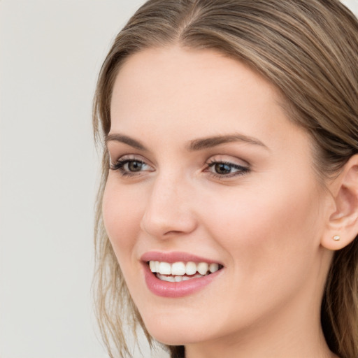 Joyful white young-adult female with long  brown hair and grey eyes