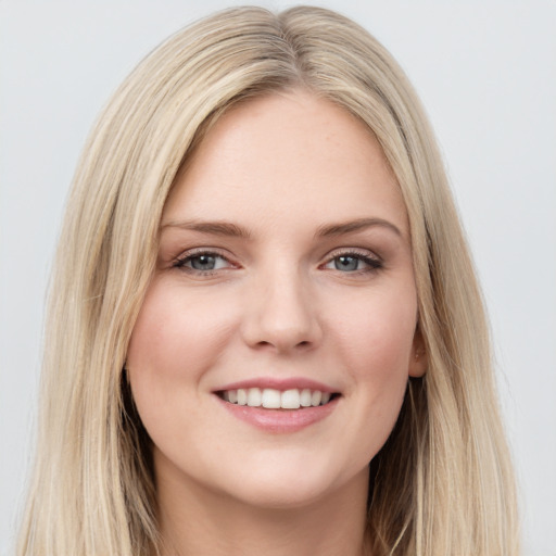 Joyful white young-adult female with long  brown hair and blue eyes